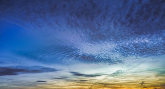 A vivid sunset showcasing dramatic cloud formations and colorful sky hues.