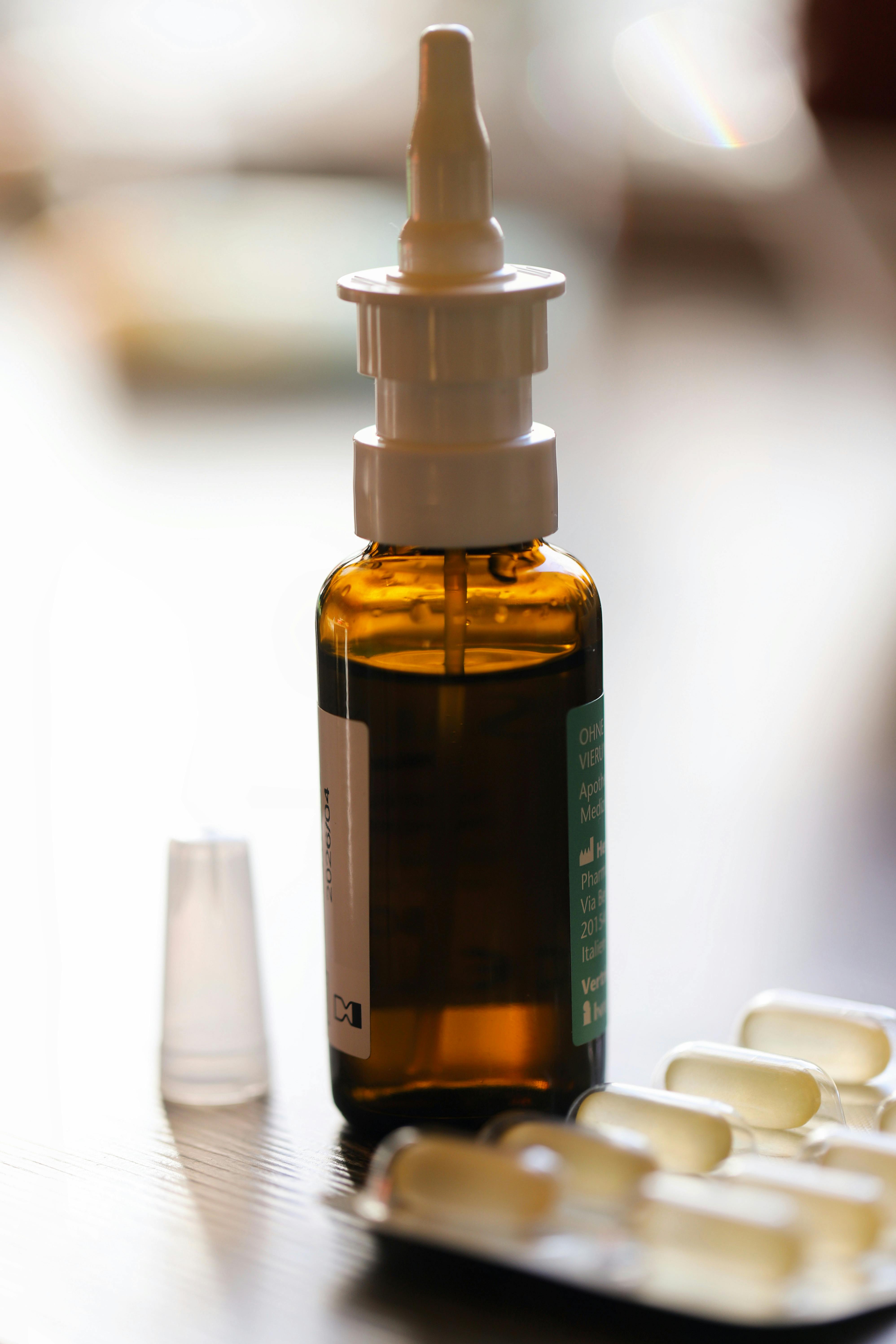 Close-up of a nasal spray bottle and capsules, ideal for healthcare use.