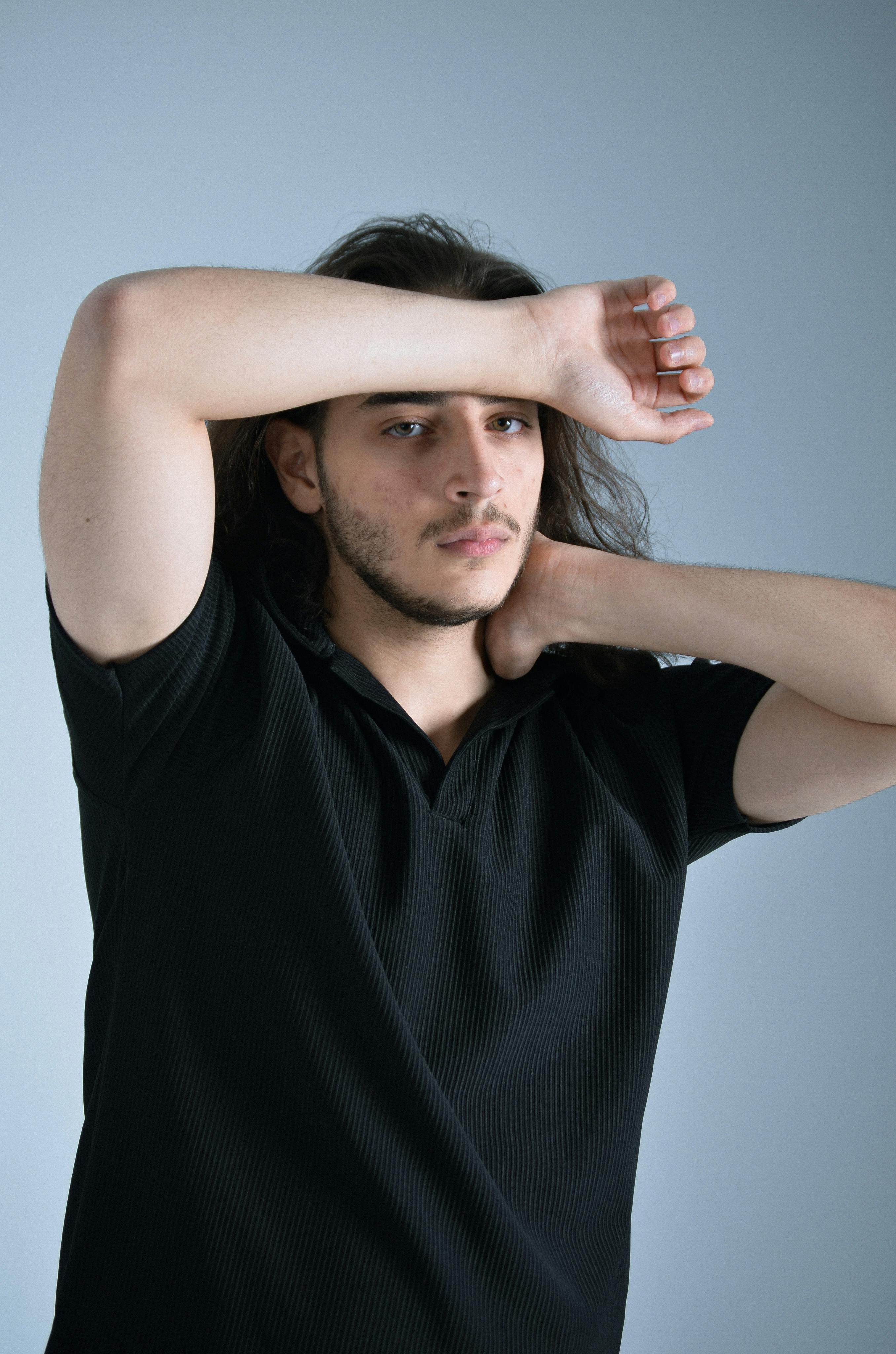 grátis Jovem adulto posando em ambiente interno com expressão e postura casuais. Foto profissional