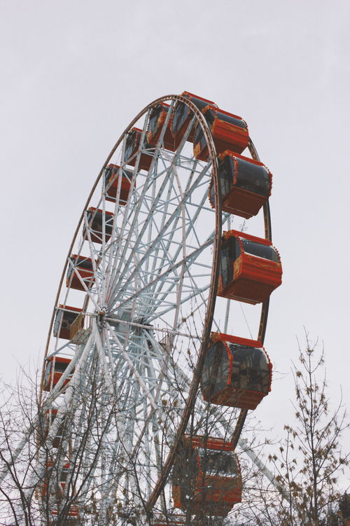 Free A nostalgic Ferris wheel stands tall against a serene winter sky. Stock Photo