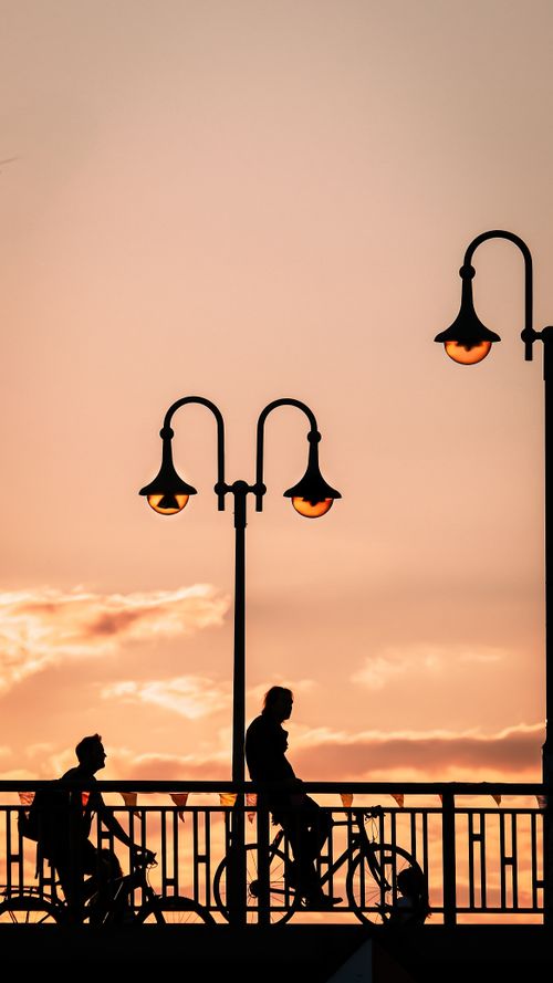Free Artistic silhouette of cyclists on a Berlin bridge during sunset, capturing urban life. Stock Photo