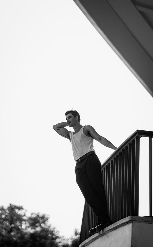 Free Striking black and white portrait of a man standing on a balcony outdoors. Stock Photo