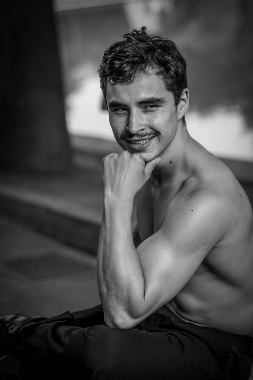 Free Black and white portrait of a confident young man posing shirtless outdoors. Stock Photo