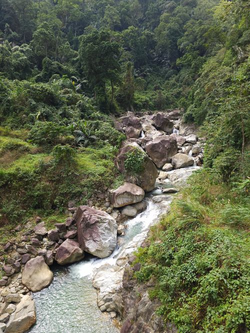 Free Lush green landscape with rocks and stream in Kon Tum, Vietnam offers a serene natural view. Stock Photo