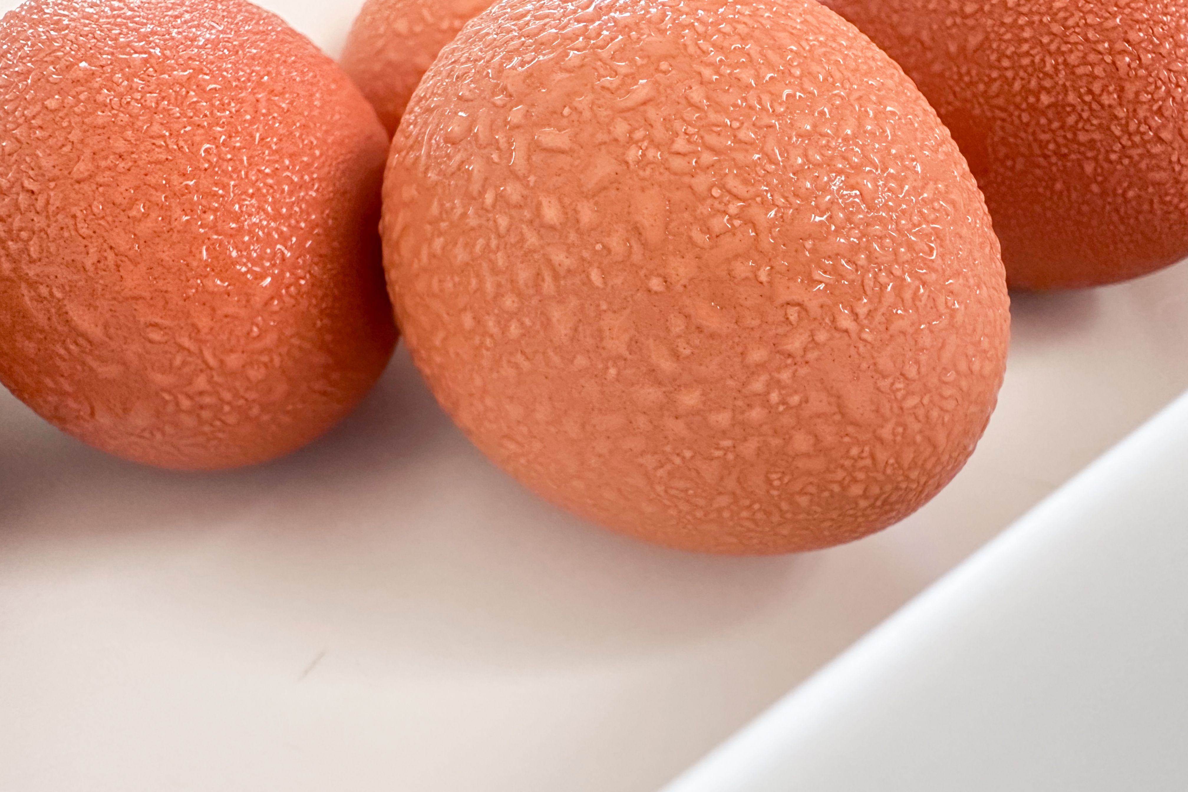 Textured brown eggs with condensation on a clean white background.