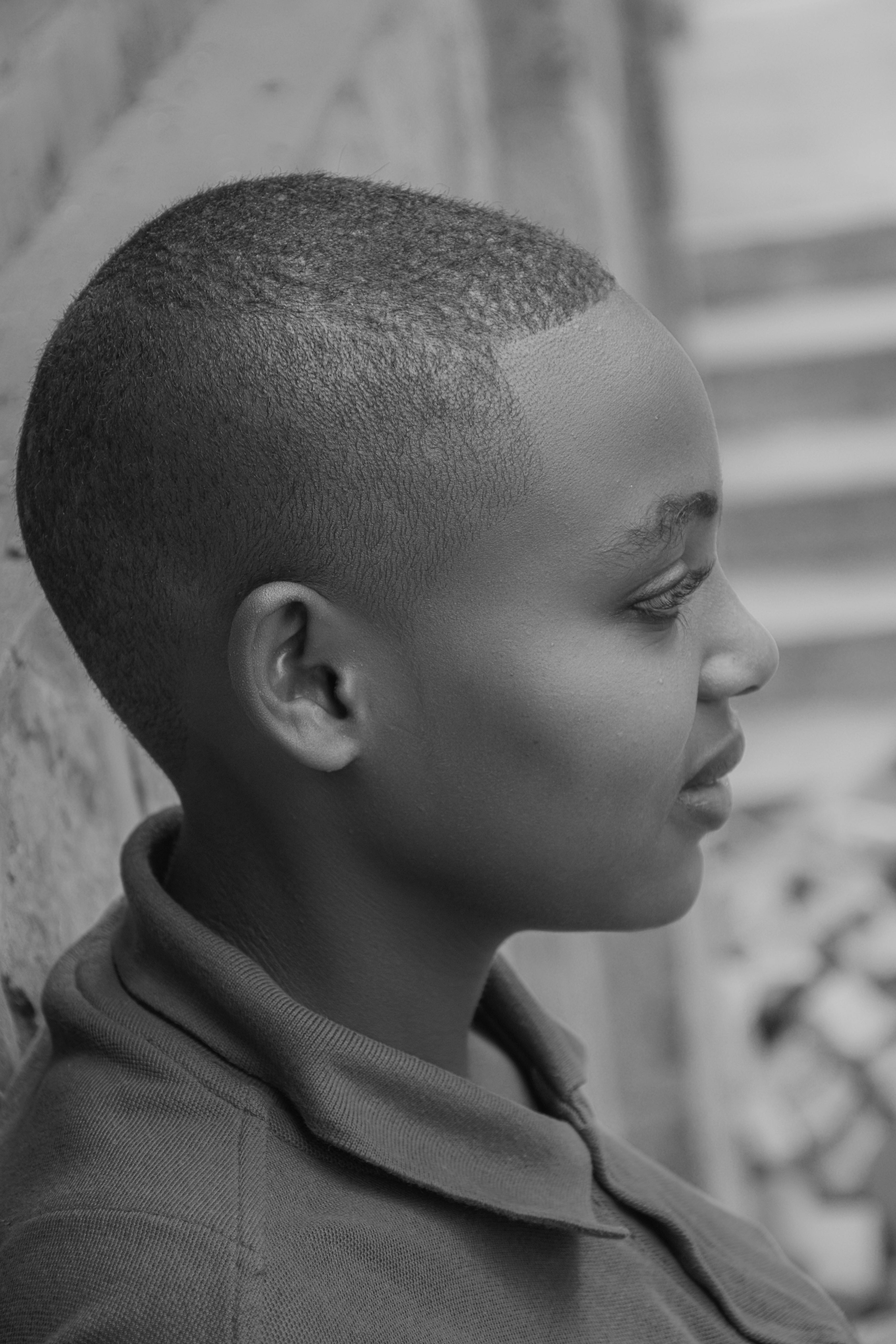 Black and white profile portrait of a smiling young adult with short hair, showcasing a serene expression.