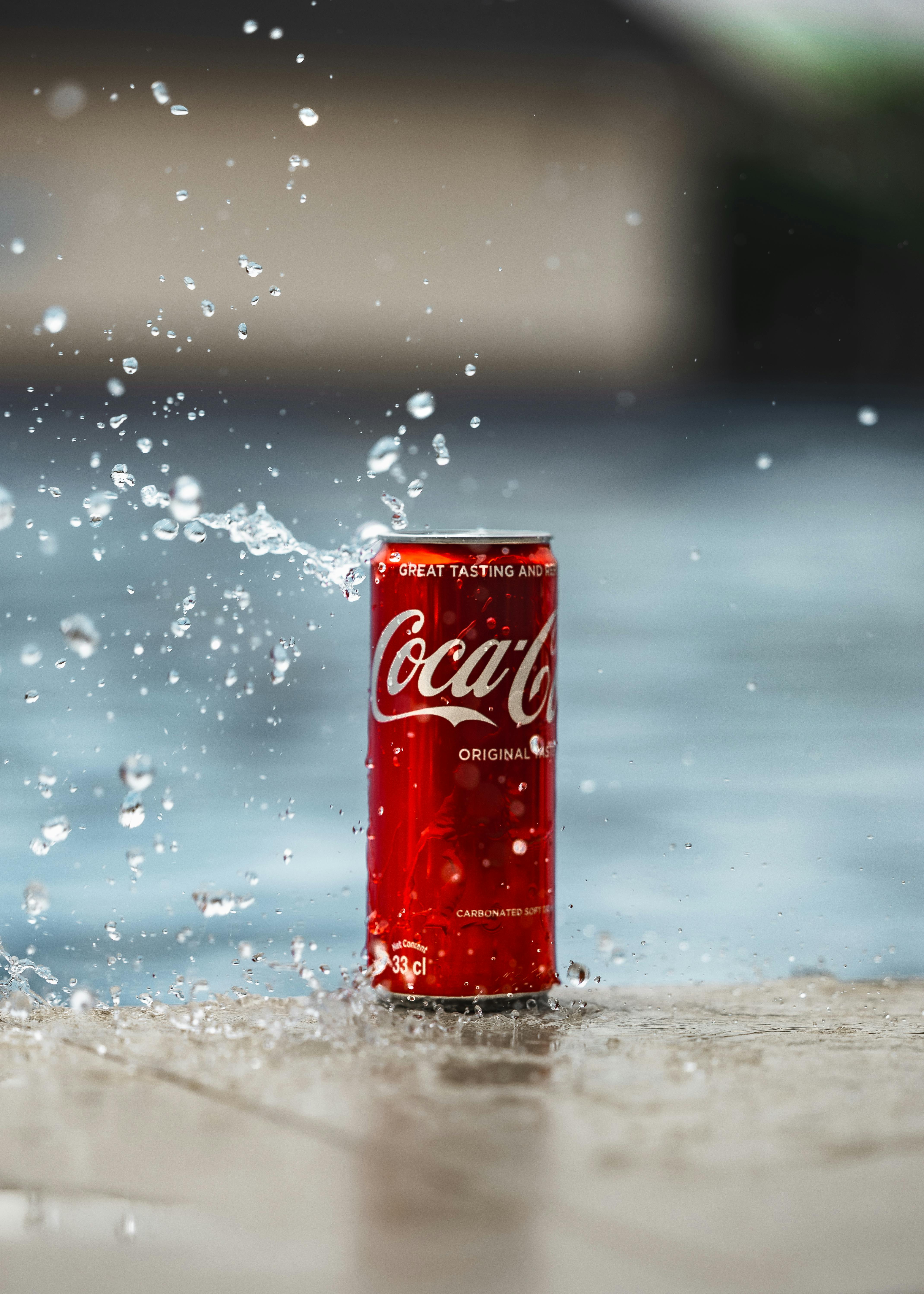 refreshing coca cola can splashing in water