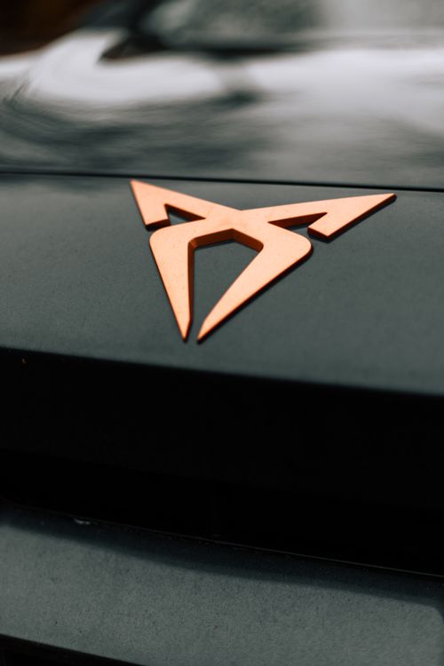Free A detailed close-up of an elegant car emblem featuring sleek design on a dark surface. Stock Photo