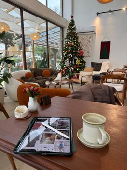 Inviting cafe interior with holiday decorations, featuring a Christmas tree and a digital tablet on a table.