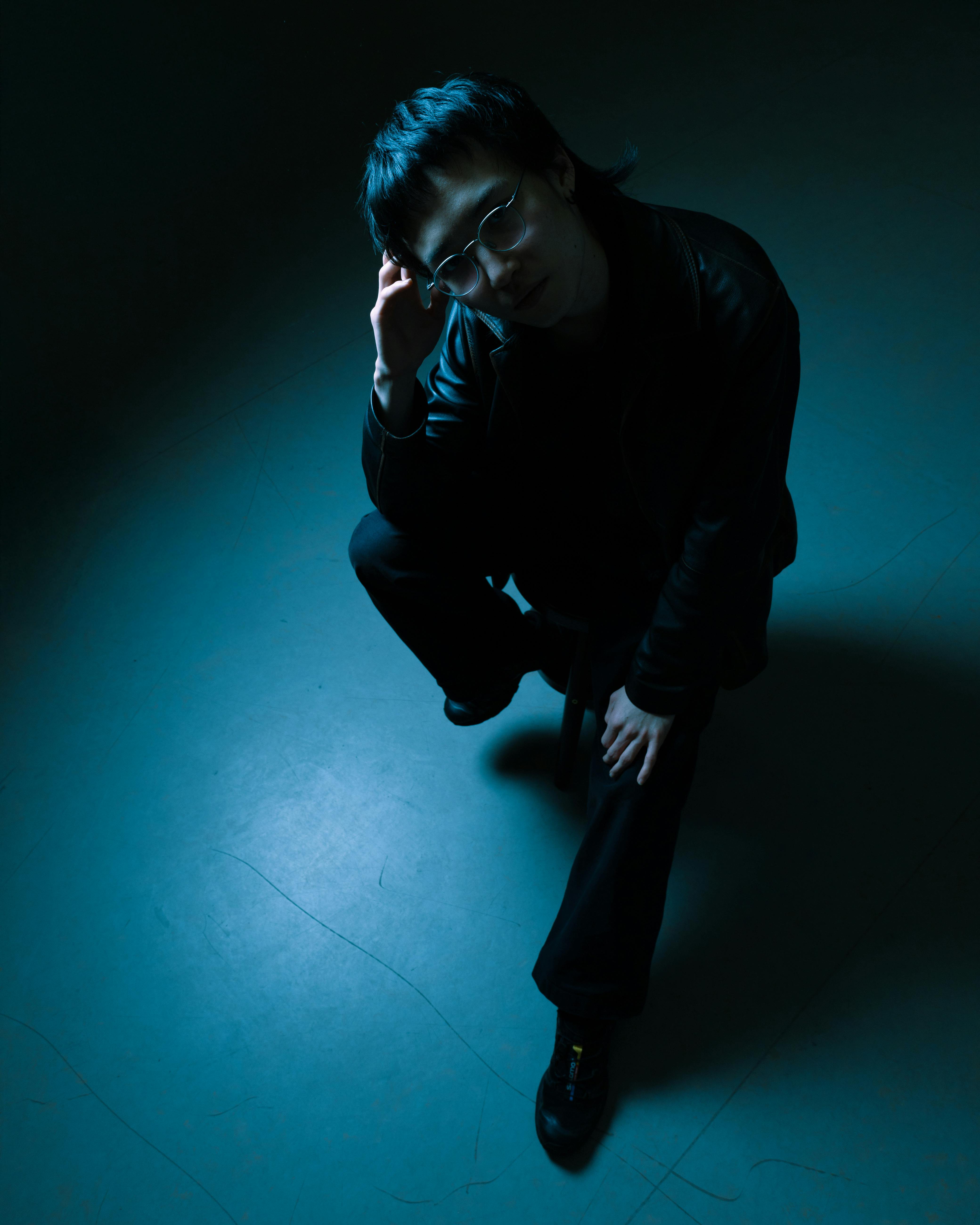 A person in deep thought, illuminated by moody lighting, creating a dramatic portrait.