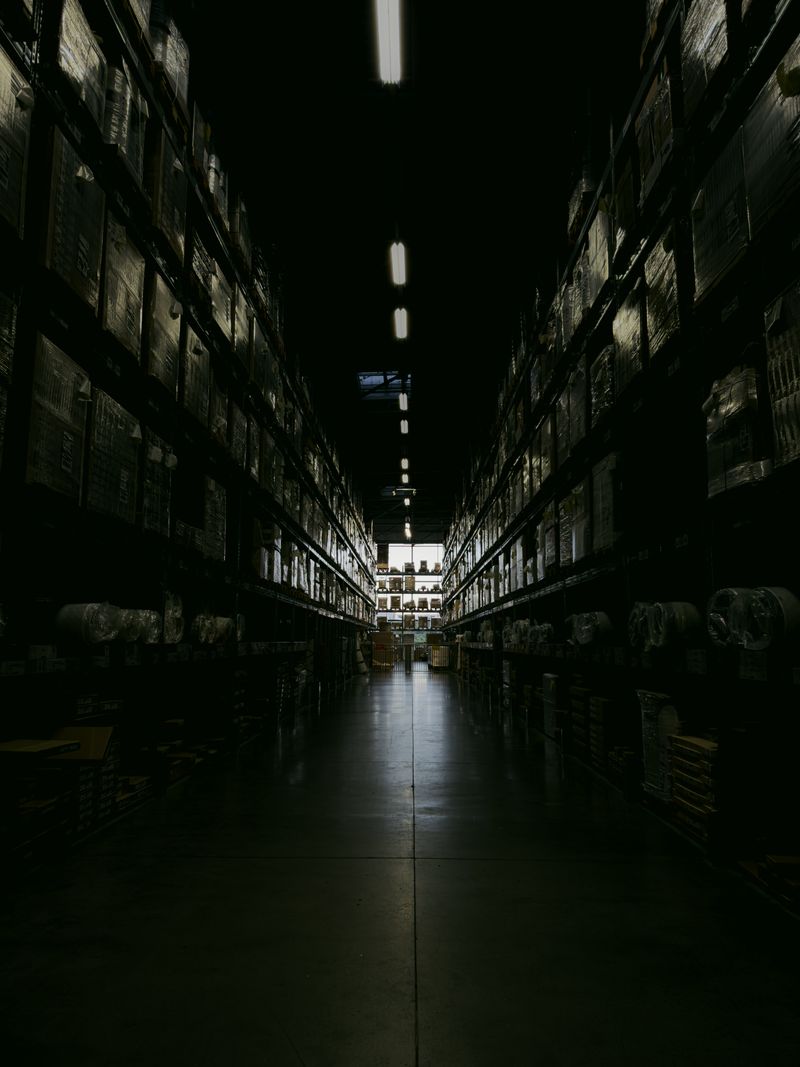 Warehouse aisle with tall shelving stocked with boxed goods