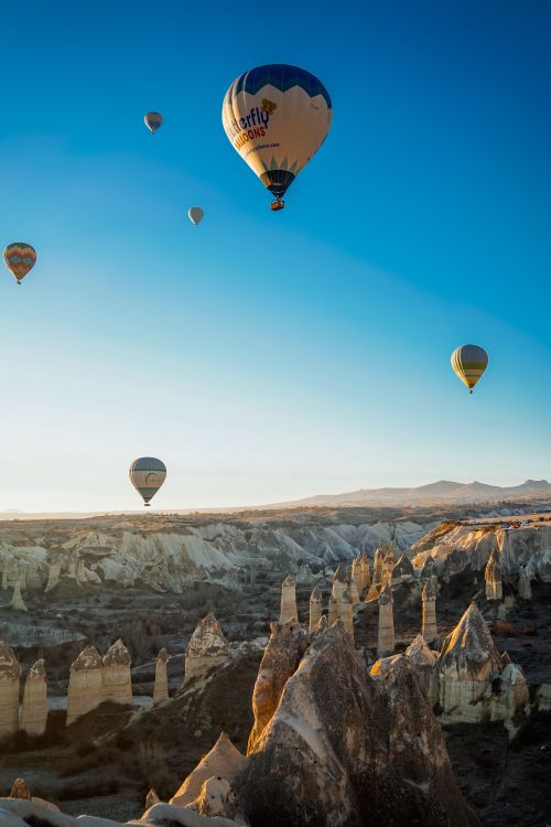 Free Hot air balloons floating over the stunning rock formations of Cappadocia at sunrise. Stock Photo