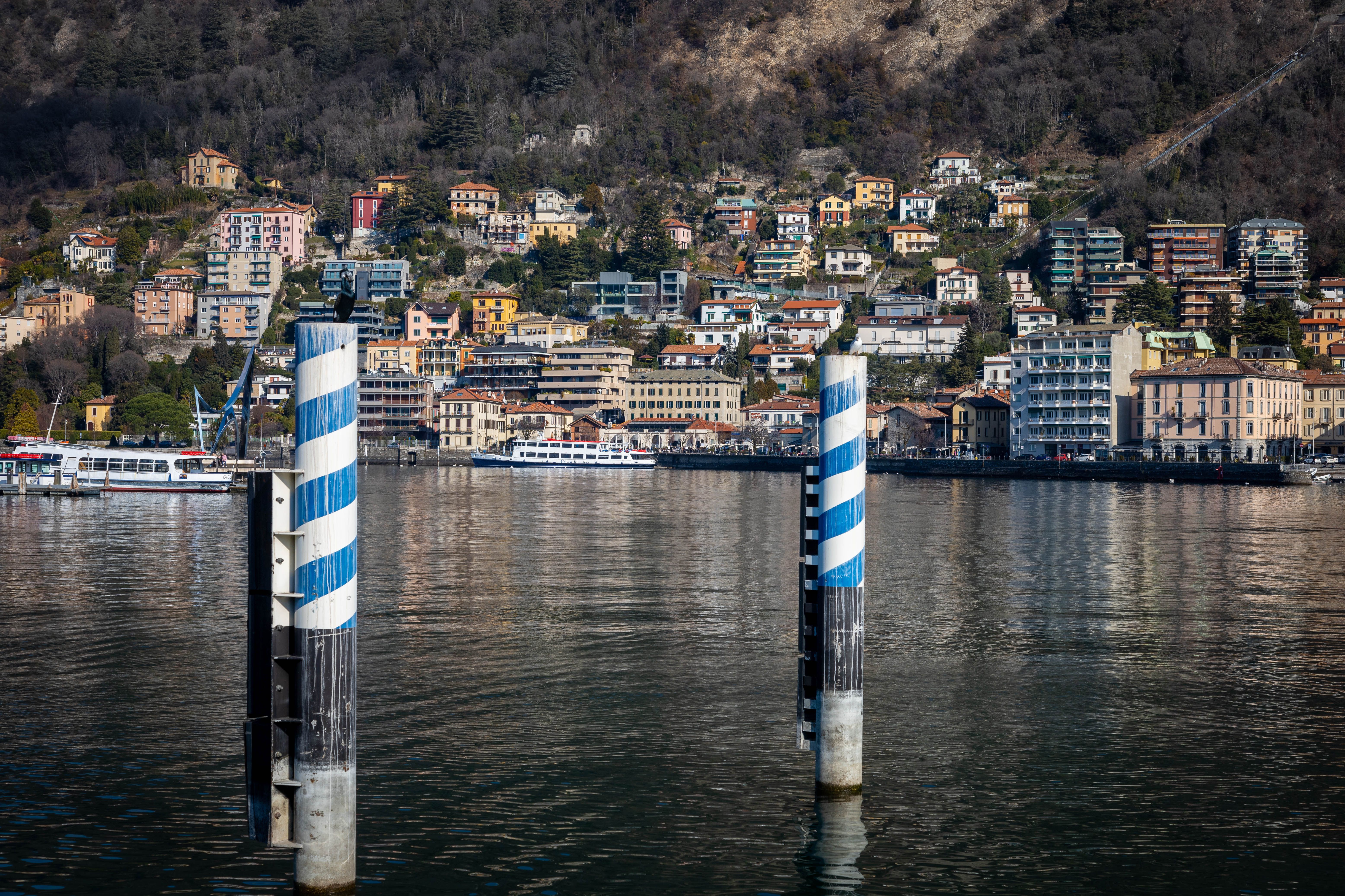 Scenic view of colorful houses along Lake Como with boats and waterfront elements.