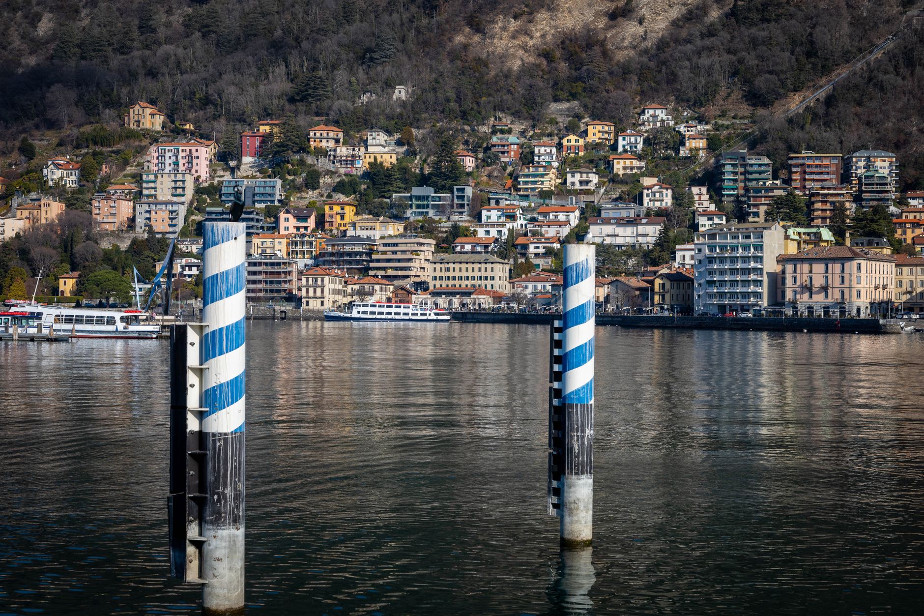 Scenic view of colorful houses along Lake Como with boats and waterfront elements.