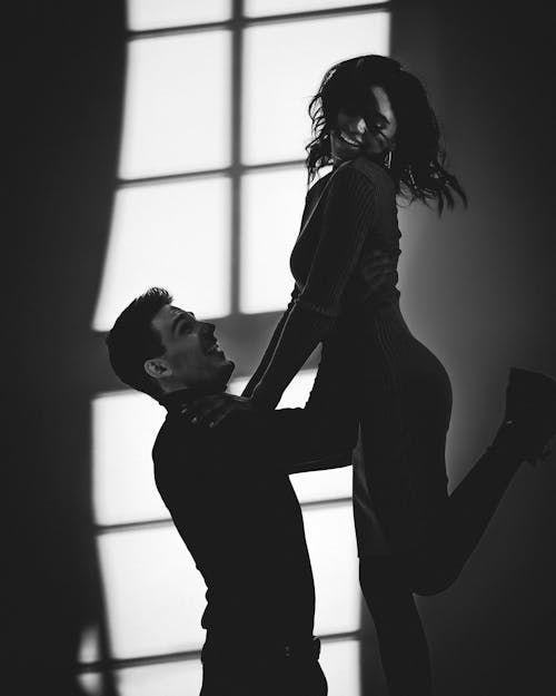 Photographie En Niveaux De Gris D'un Homme Soulevant Une Femme