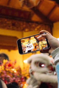 A vibrant lion dance performance captured on a smartphone during a festive celebration.