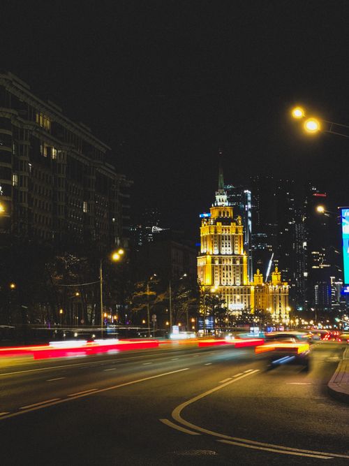 Free Vibrant city skyline at night, showcasing light trails from speeding cars and illuminated buildings. Stock Photo