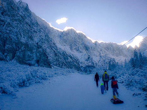 A family enjoying a winter sledding trip in the snowy Slovenian mountains, capturing seasonal joy.