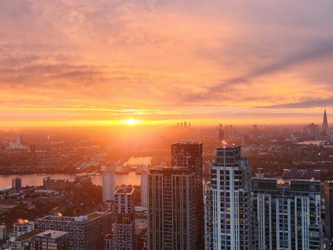 Breathtaking view of London's skyline during a vibrant sunset over the River Thames.