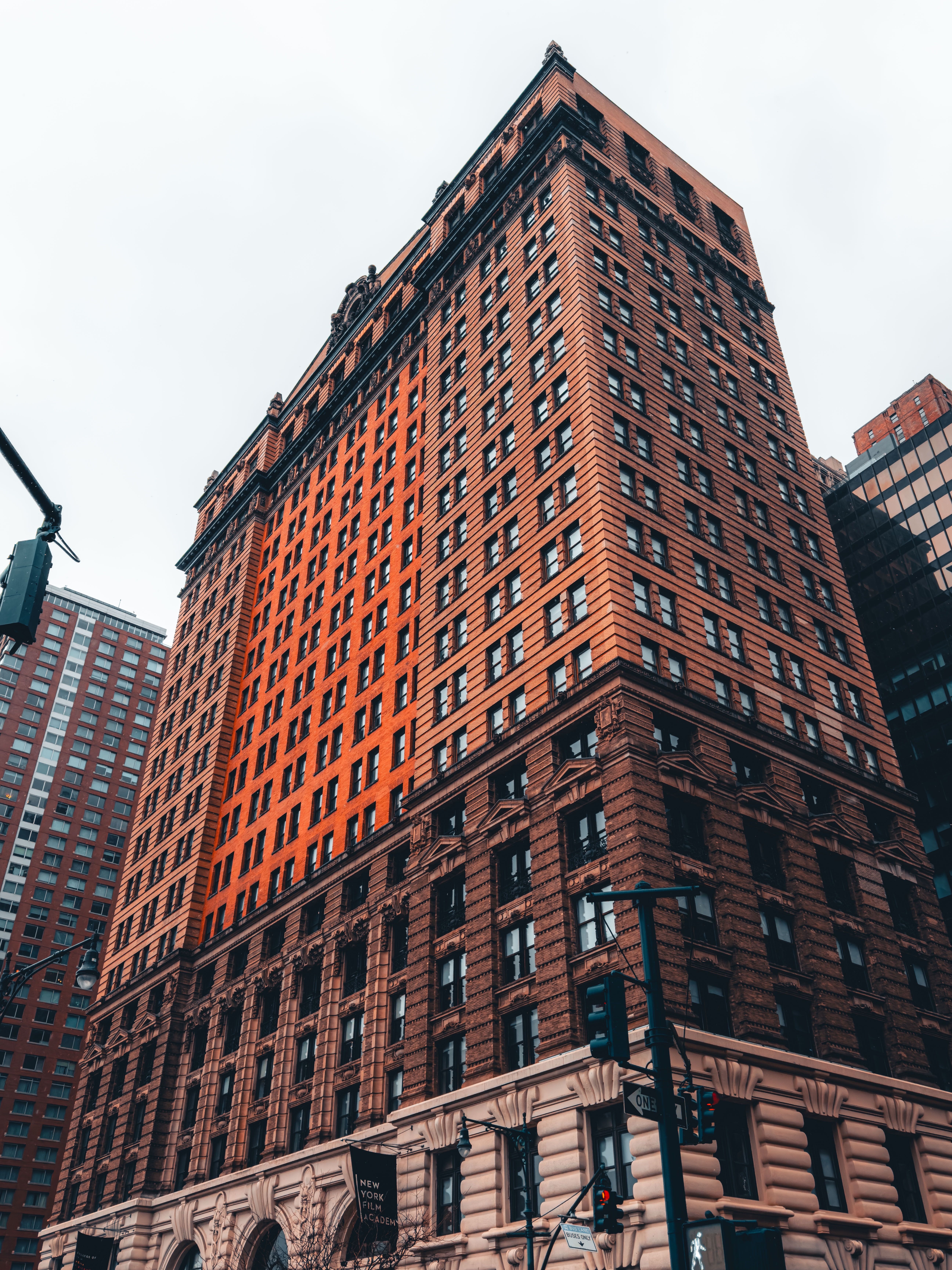 Historic Brick Skyscraper Under Cloudy Sky · Free Stock Photo