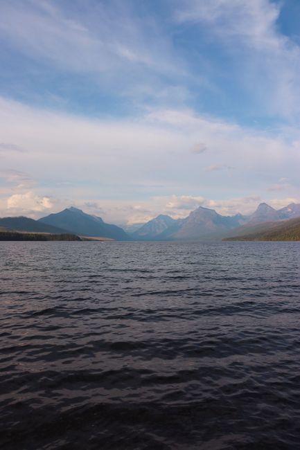 Tranquil scene of mountains and lake under a serene sky in Glacier National Park, Montana.