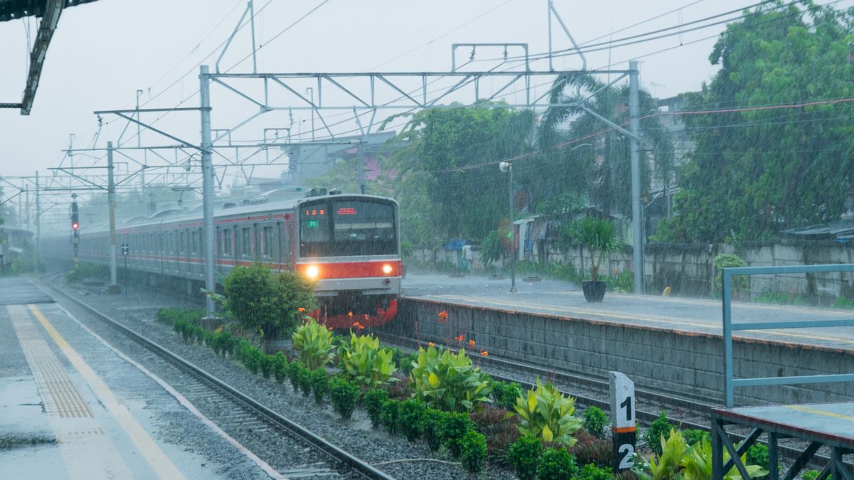 激しい雨の中、駅のホームへ入ってくる電車