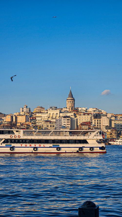 Free Scenic view of Istanbul's skyline with a ferry on the Bosphorus and Galata Tower in the background. Stock Photo