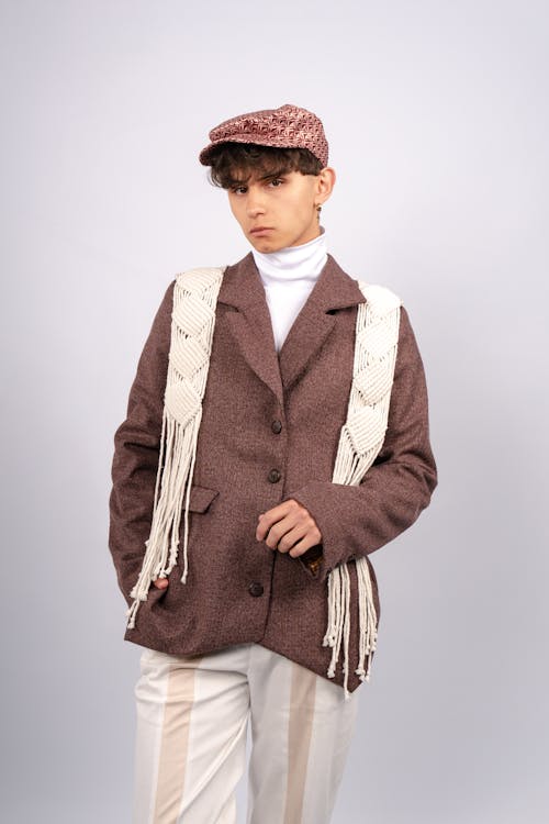 Free Teenager modeling a vintage outfit with macrame details, wearing a cap indoors. Stock Photo