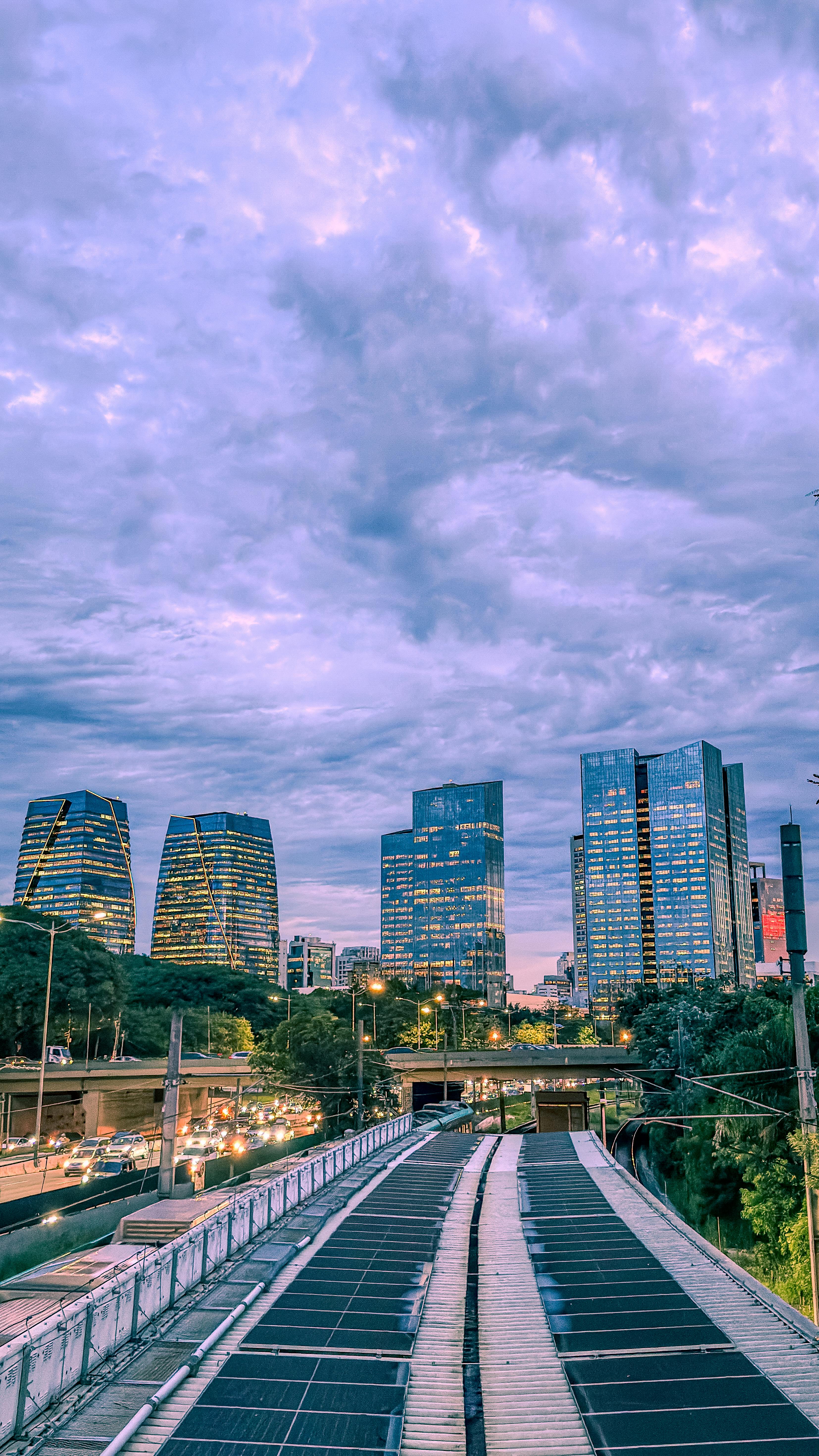 Free A view of S&atilde;o Paulo's skyline at dusk with modern skyscrapers and dramatic clouds. Stock Photo