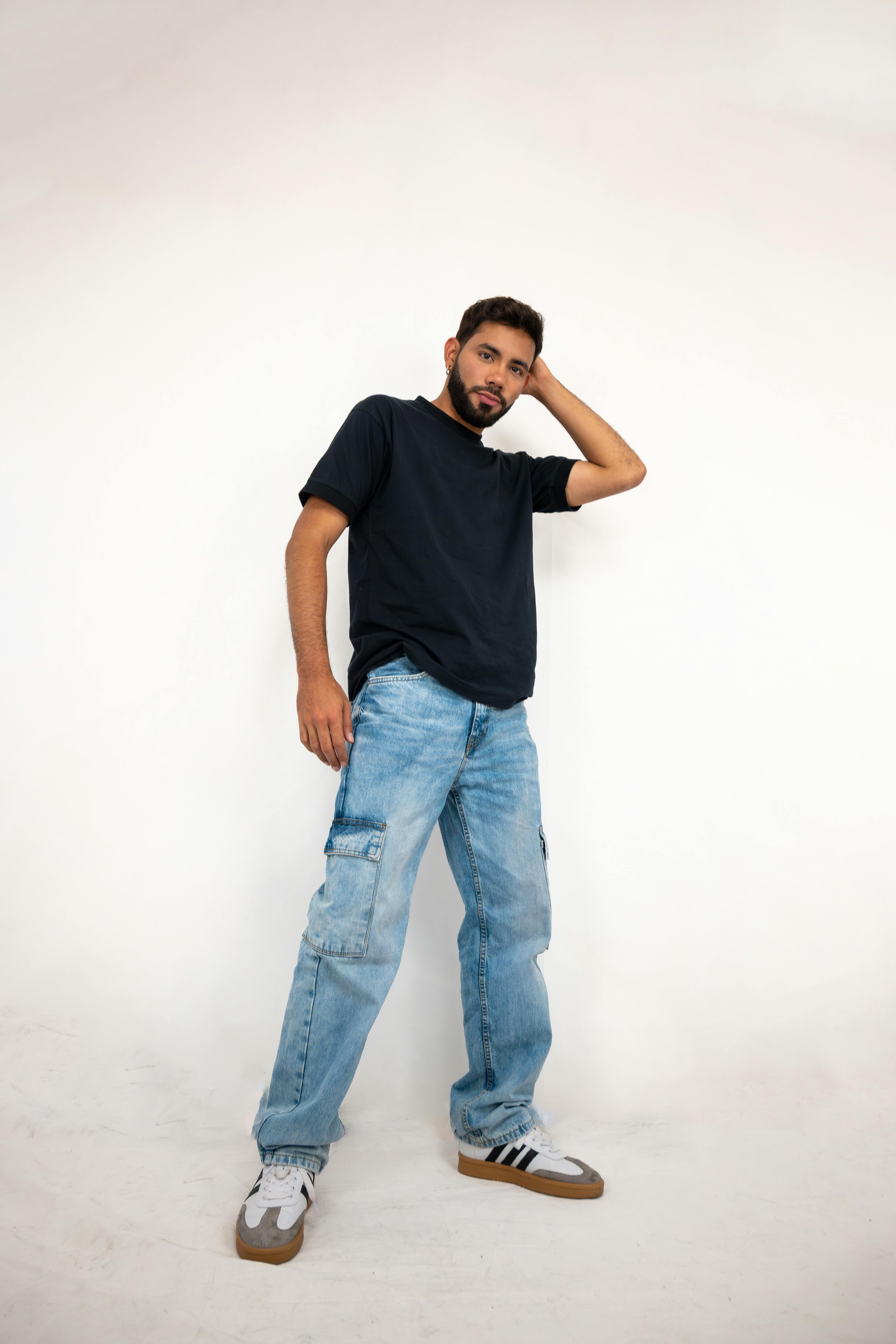 Miễn phí Chàng trai trẻ sành điệu tạo dáng trong trang phục thường ngày trên nền studio màu trắng. Ảnh lưu trữ