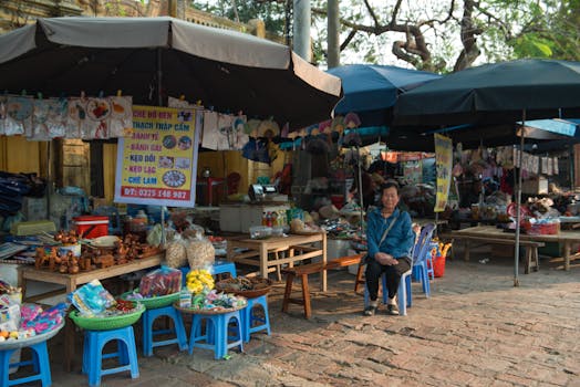 Explore a bustling street market in Hanoi, Vietnam with a variety of goods and a friendly vendor.