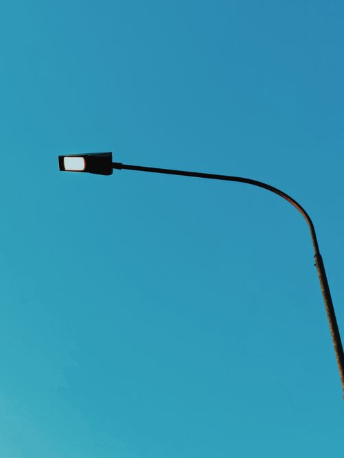 Free Simple streetlight against a clear blue sky, representing minimalism and urban serenity. Stock Photo