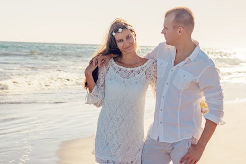 Woman and Man Standing Near on Body of Water