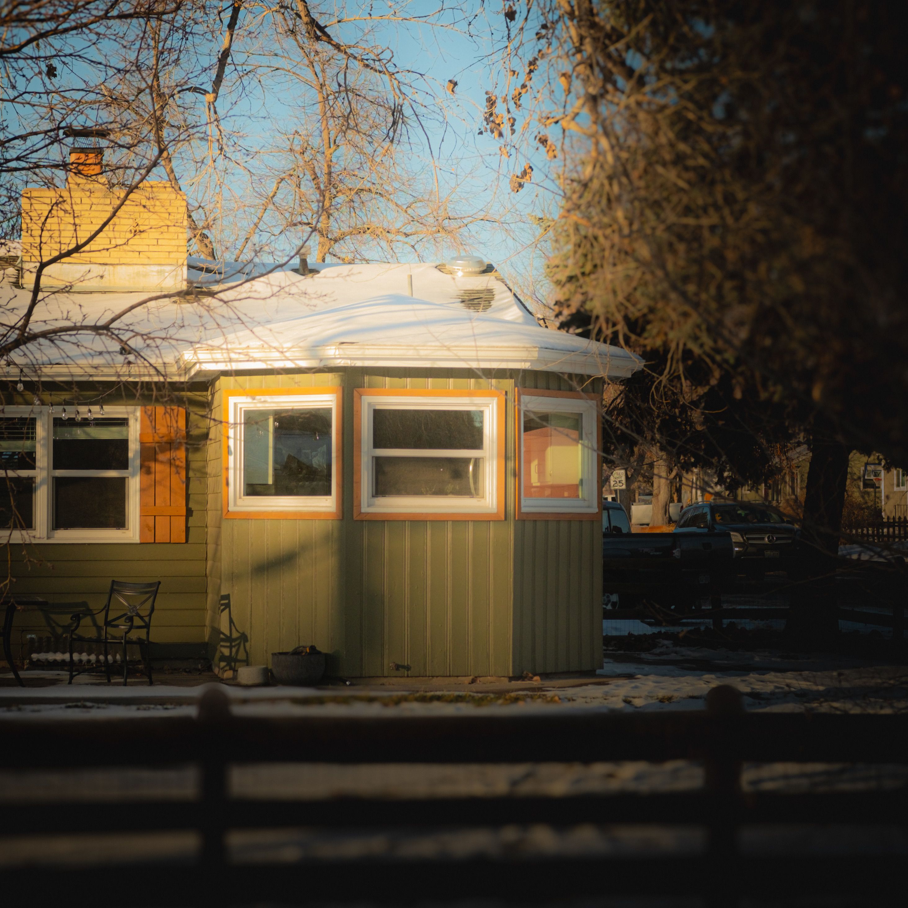 A suburban house bathed in warm winter sunlight, showcasing architecture and seasonal charm.
