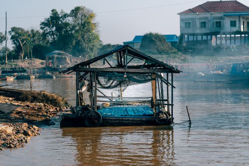 Free A rustic floating hut on a peaceful river setting amidst nature. Stock Photo