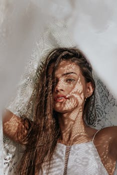 一位年轻女子的艺术肖像，脸上映着有趣的蕾丝阴影图案