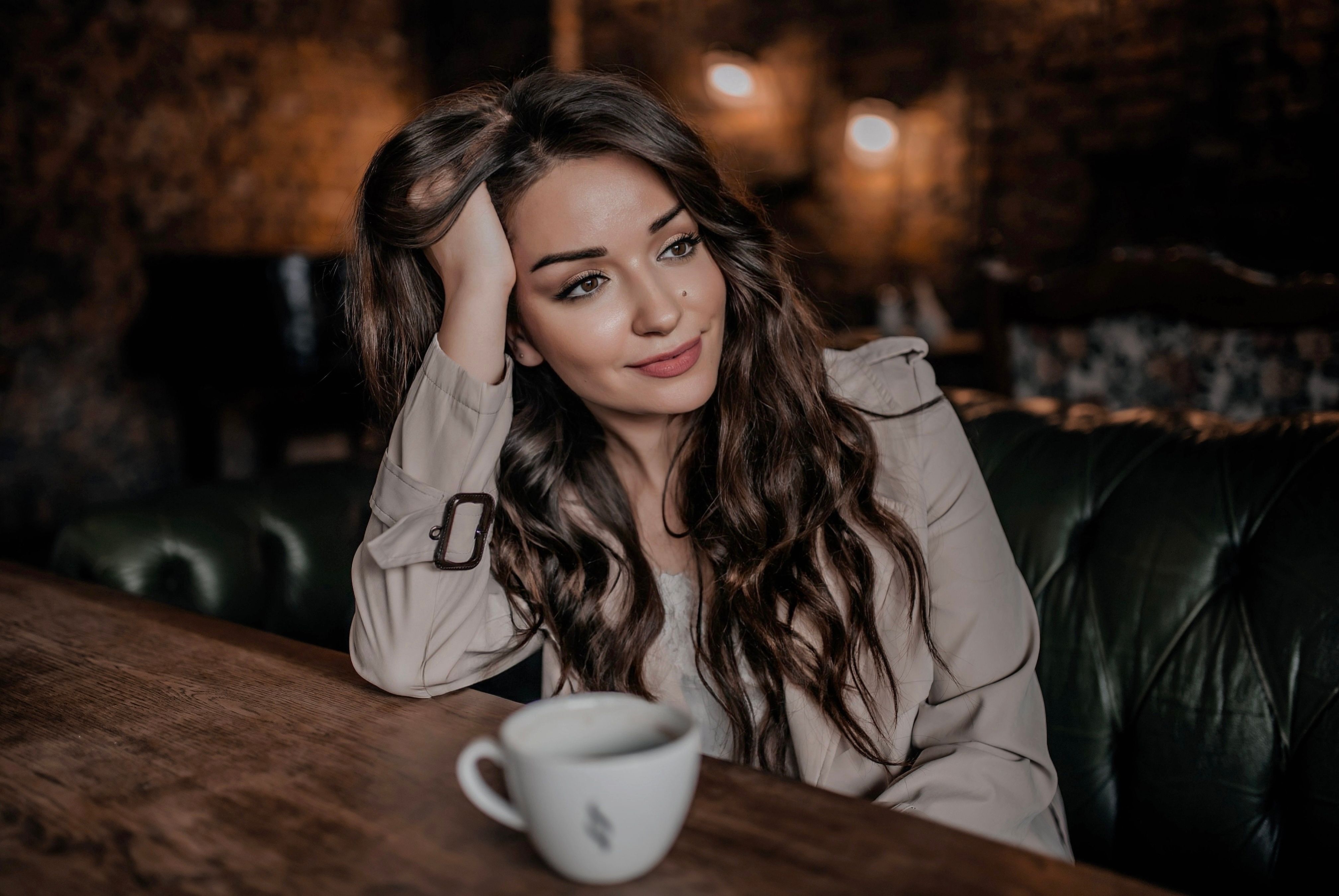 A mature woman enjoying a calm, unhurried moment with coffee, at ease and self-possessed.