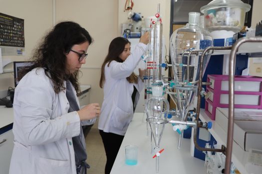 Scientists in a chemistry lab conducting experiments with precision.
