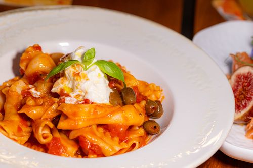Free Tasty pasta with olives and cheese garnish, ideal for culinary themes. Stock Photo