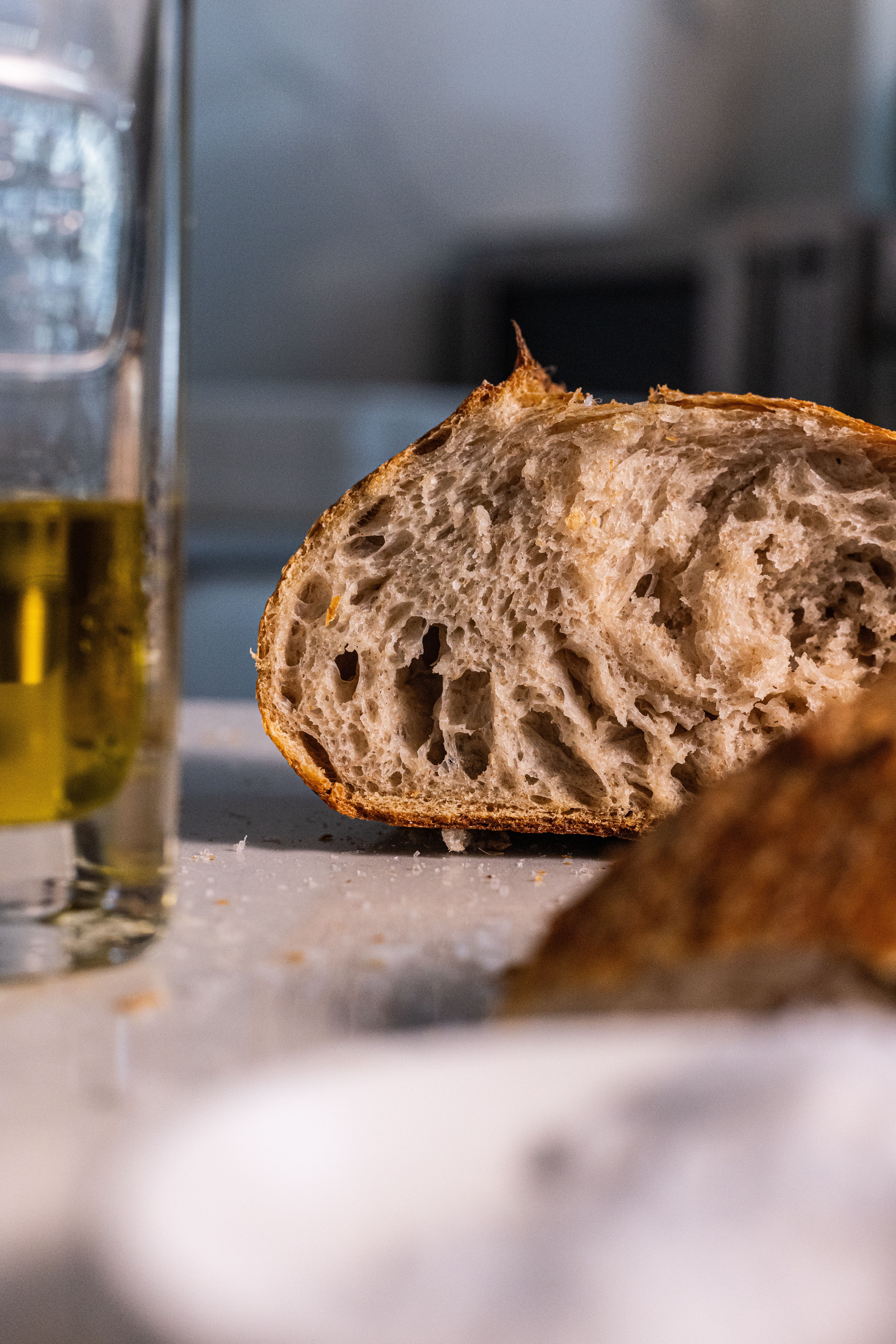 Artistic shot of rustic bread and olive oil highlighting texture and freshness.