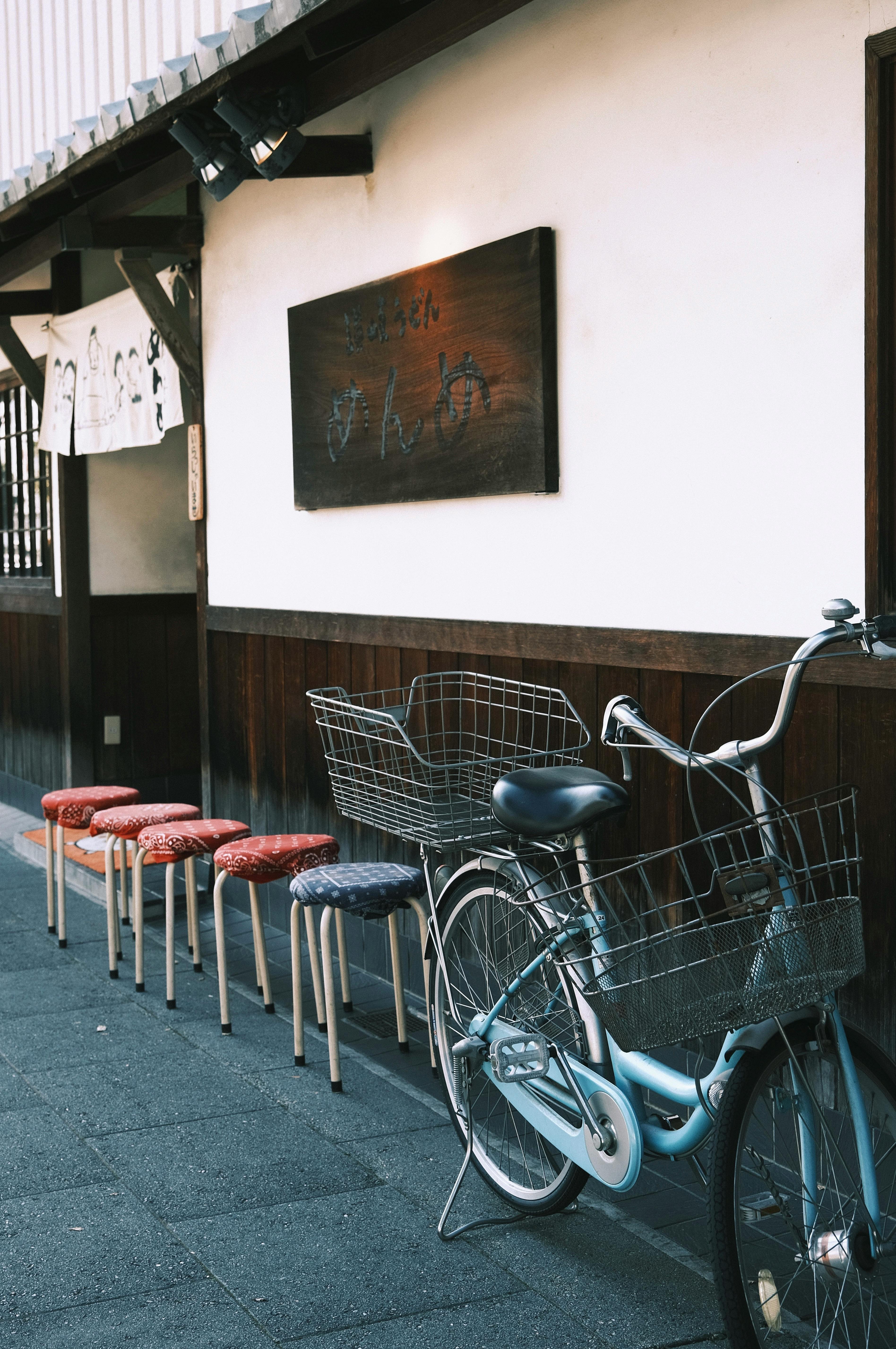 A peaceful street with a bicycle and benches in traditional Japanese style.