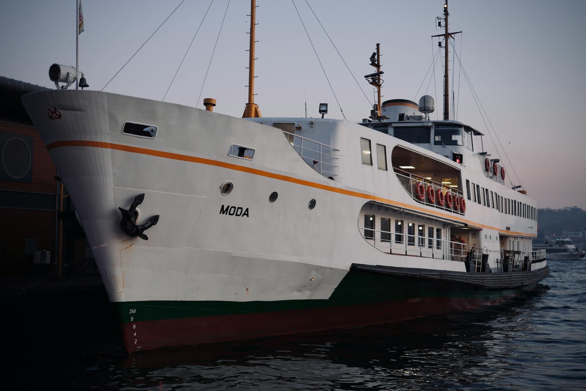 View of the Moda ferry docked at Istanbul's Moda Harbor at sunset, showcasing maritime transport.
