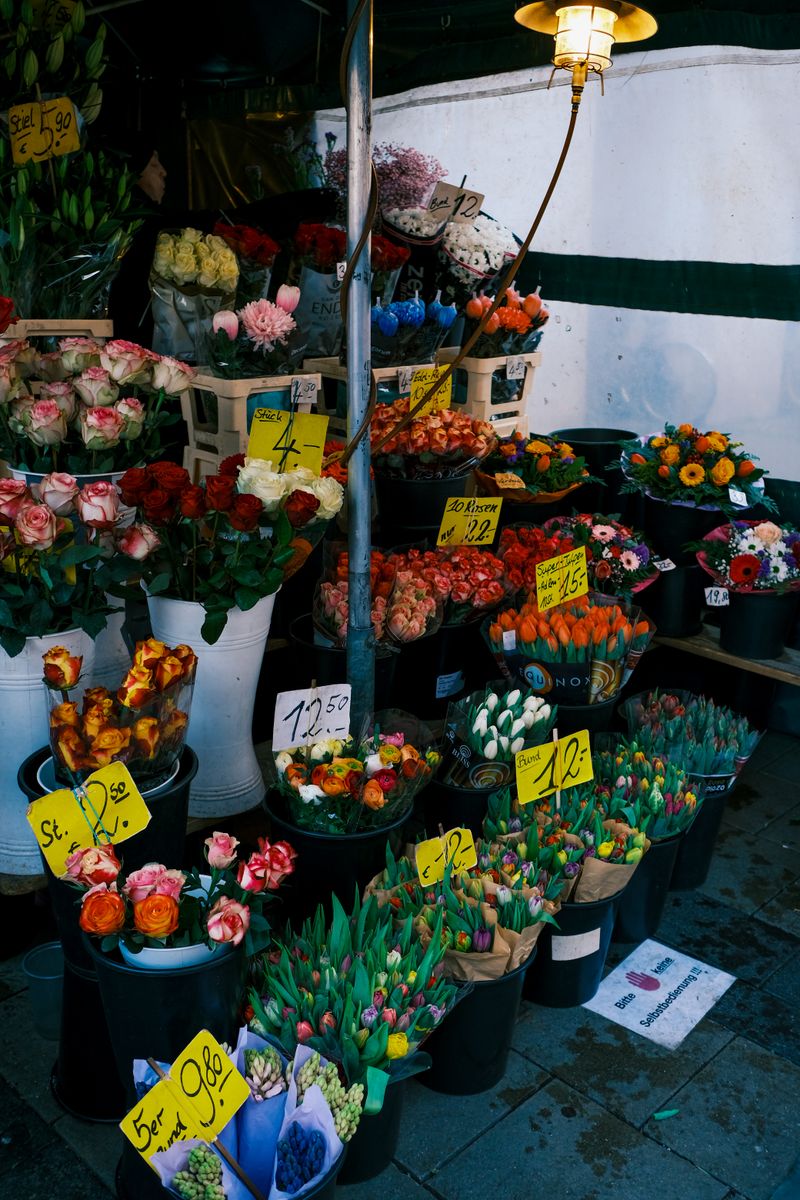 Colorful assortment of flowers at a bustling market stall.
