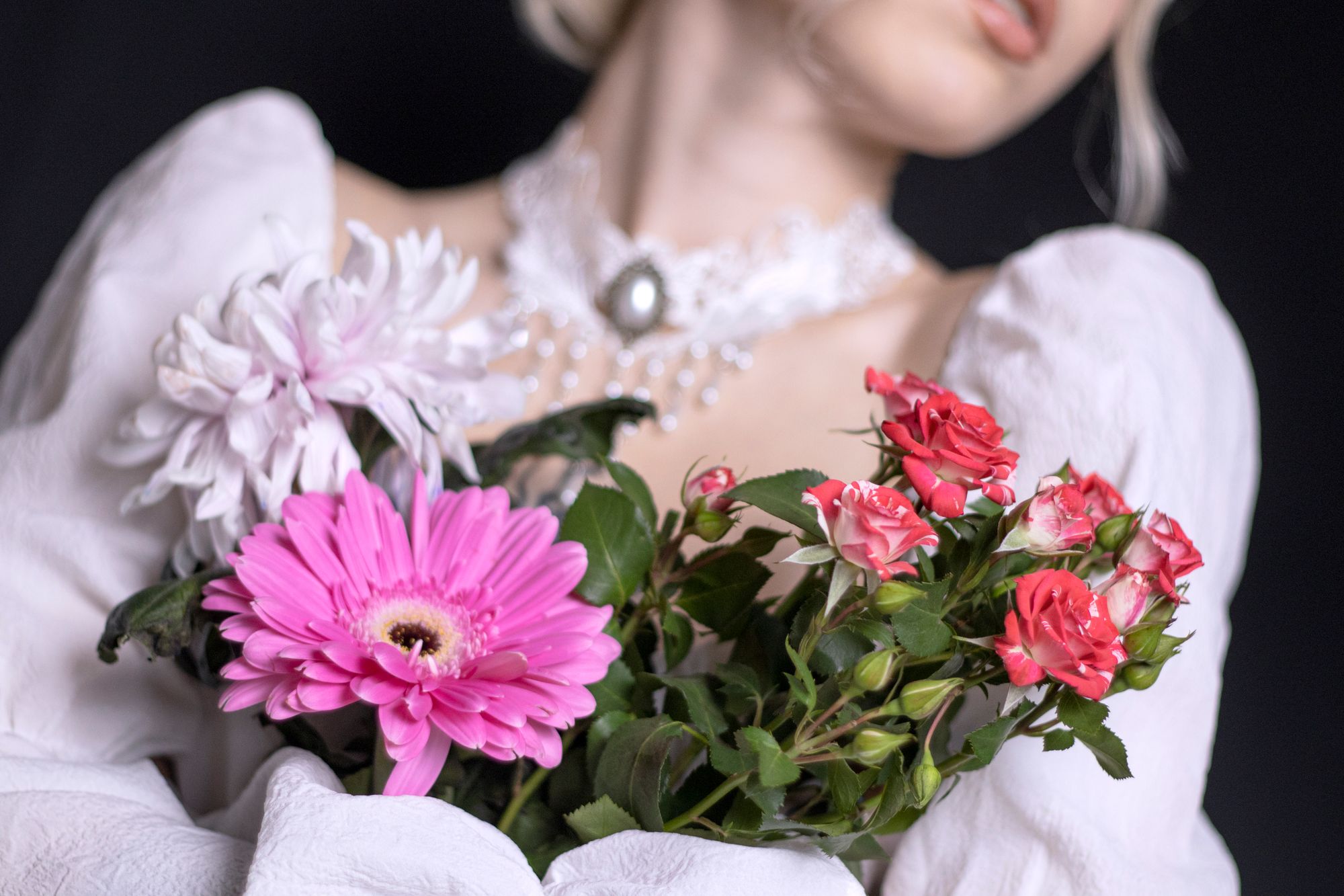 Portrait of a woman in lace holding pink and white flowers