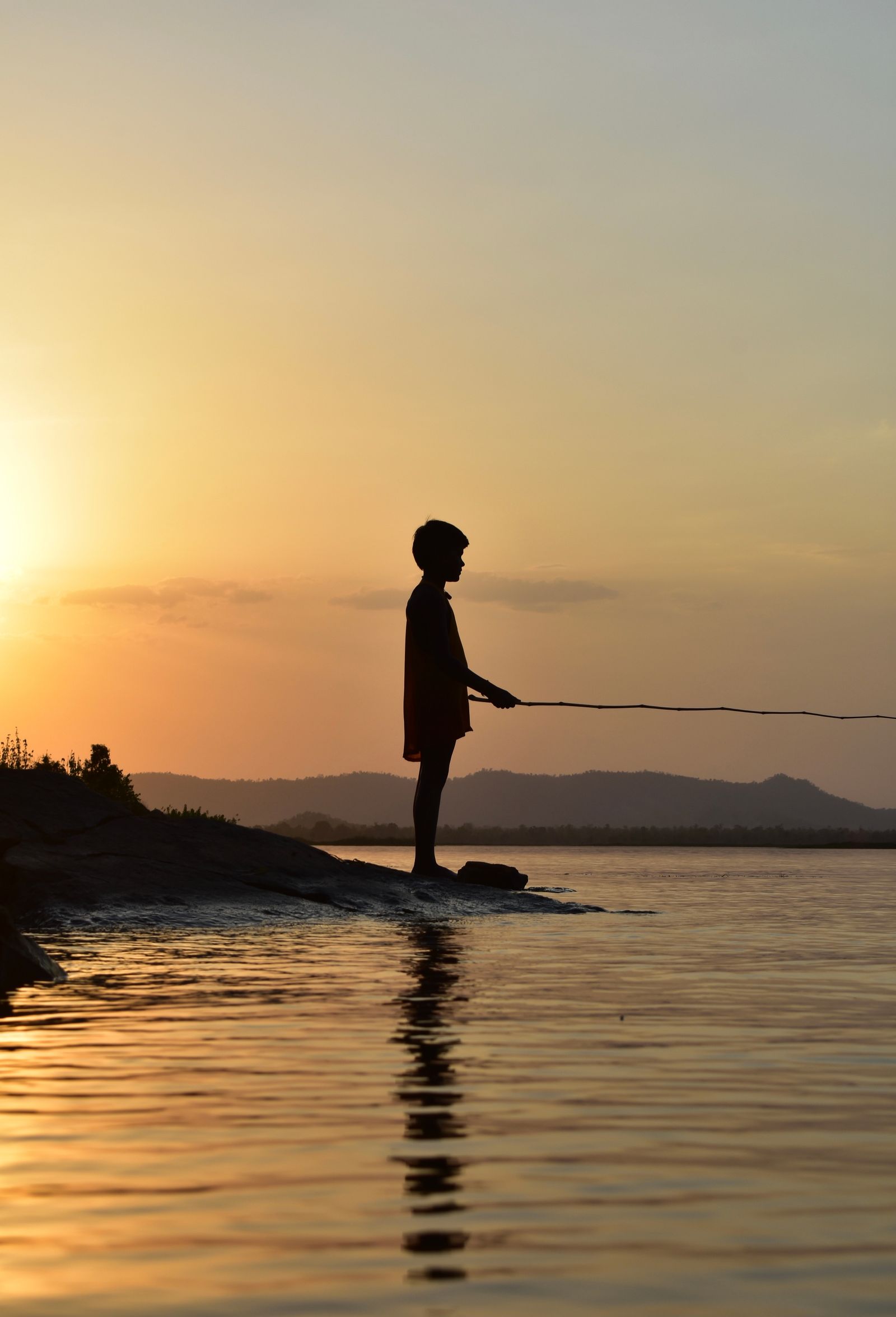 Silhouette of Little Girl on Lake Shore at Sunset · Free Stock Photo