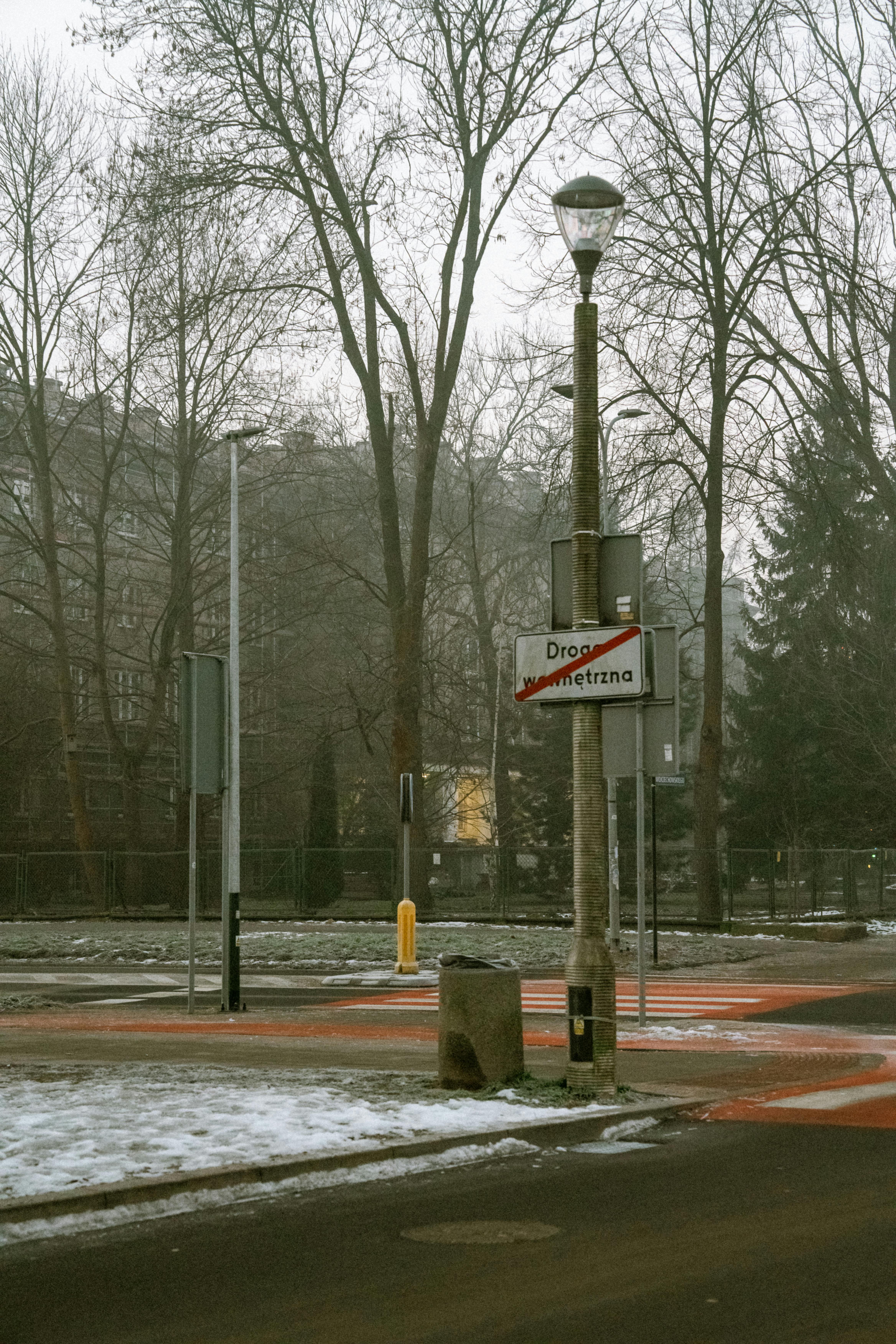 Kostnadsfria En lugn urban gatukorsning vintertid med kala träd och dimmig atmosfär. Stock foto