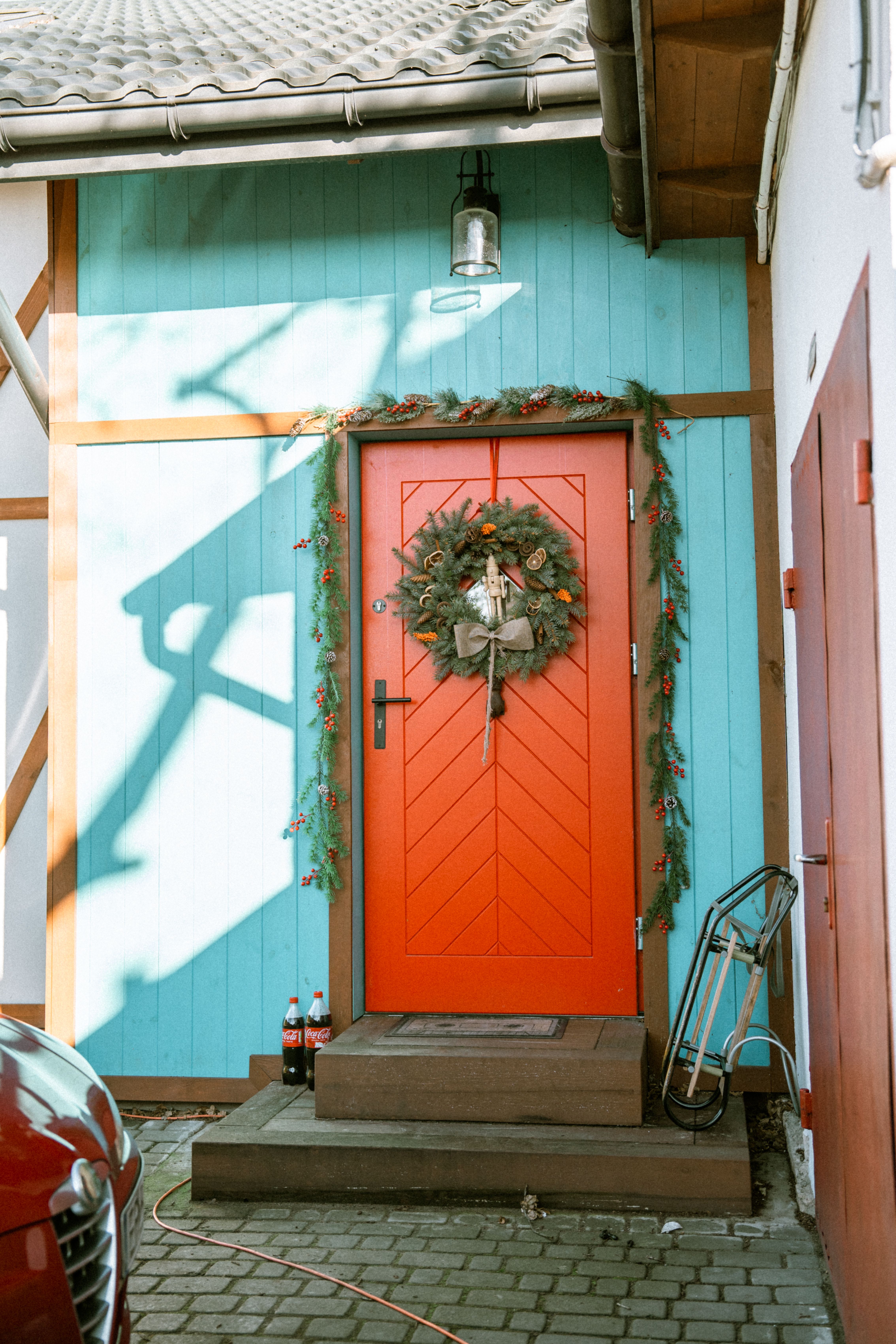 Bright red door adorned with a holiday wreath; showcasing a festive and welcoming entrance.