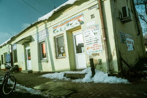 Free An old building with shop signs on a snowy street corner, bicycle parked outside. Stock Photo