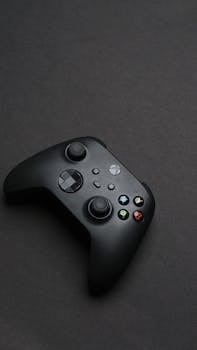 Stylish black game controller with buttons on a dark background, emphasizing modern technology.