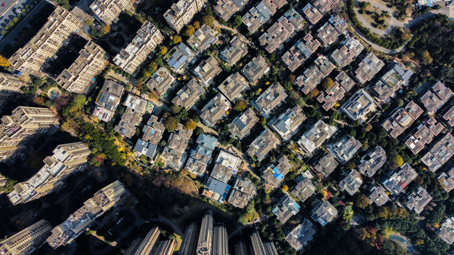 Aerial view of a planned suburban neighborhood with a circular community park and tree-lined residential streets — the master-planned community infrastructure of a family residential district.